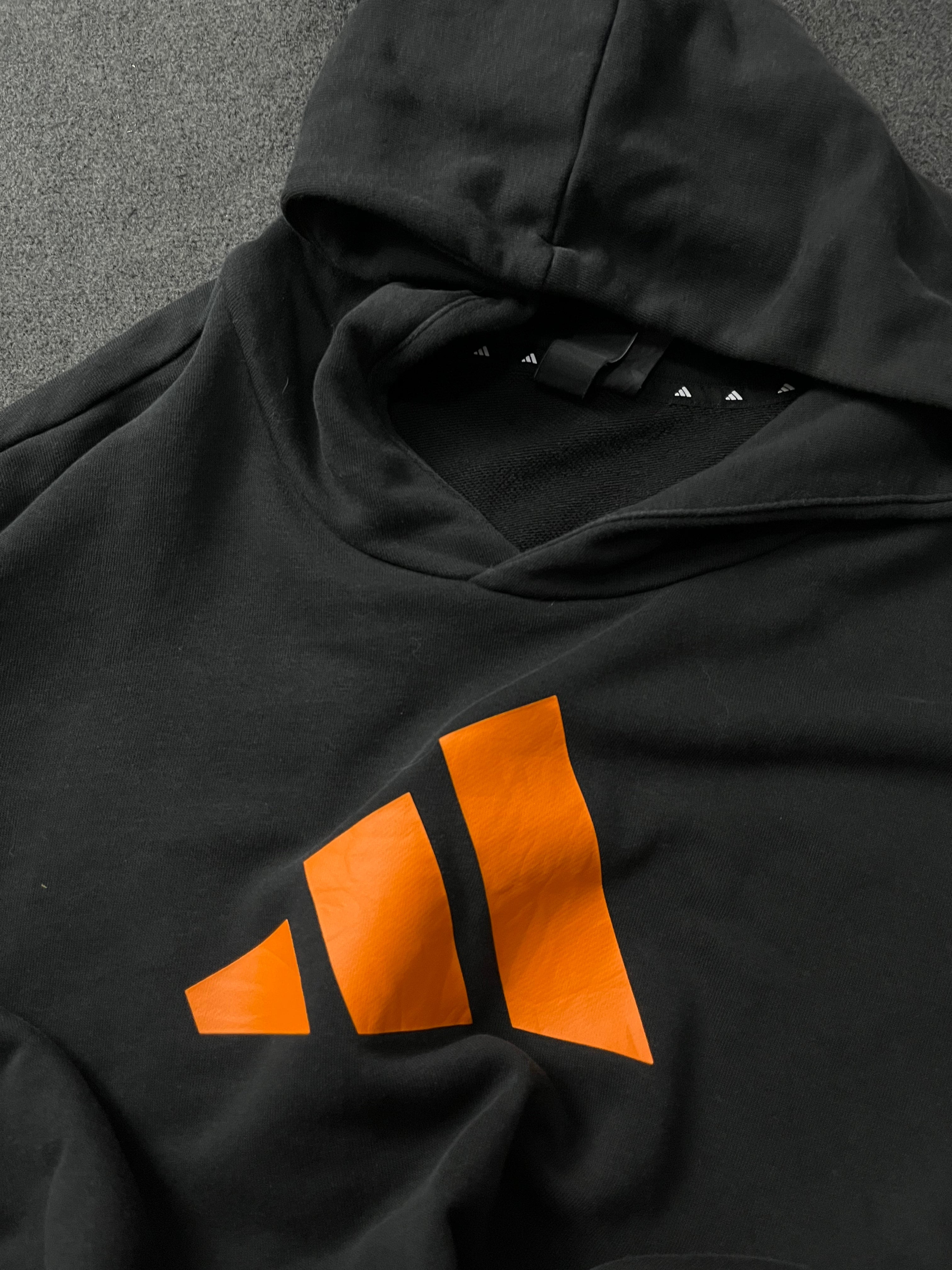 Adidas Future Icons Hoodie in black with an orange logo